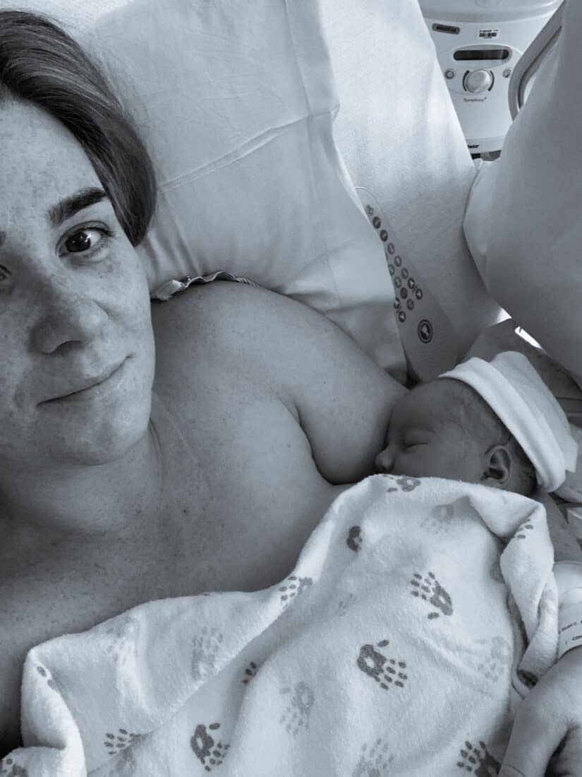 a woman in a hospital bed delivering a baby