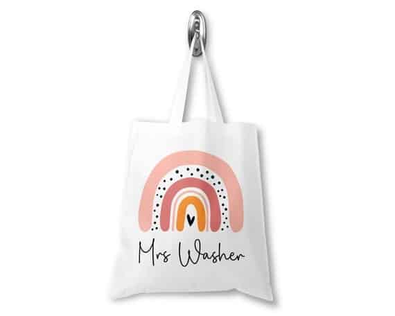 A white tote with a rainbow design personalized with a name