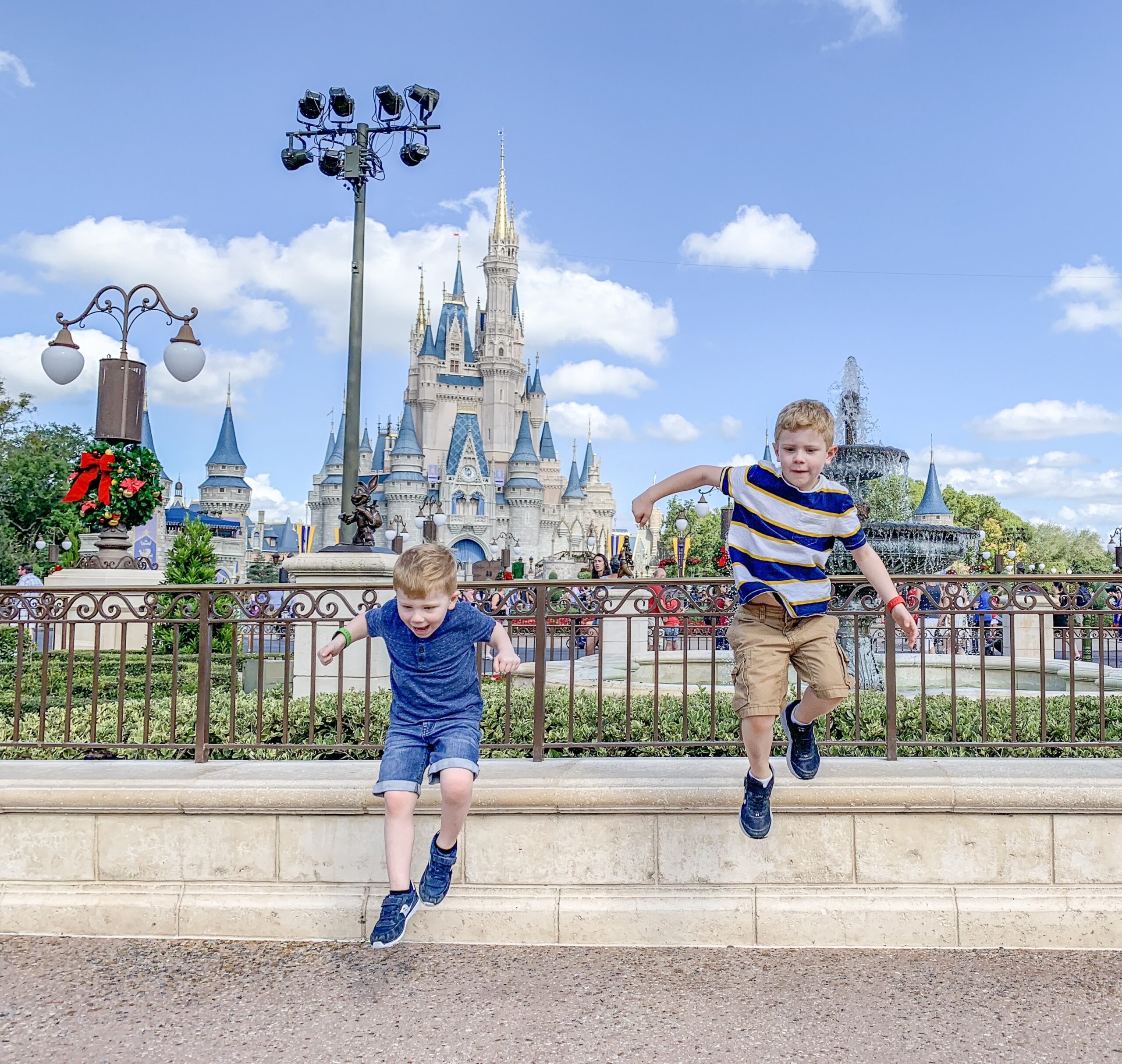 kids jumping off a rail at Disney world with the castle in the background