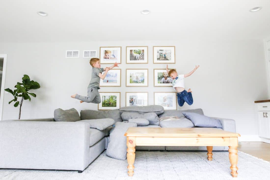 Two boys jumping on a couch