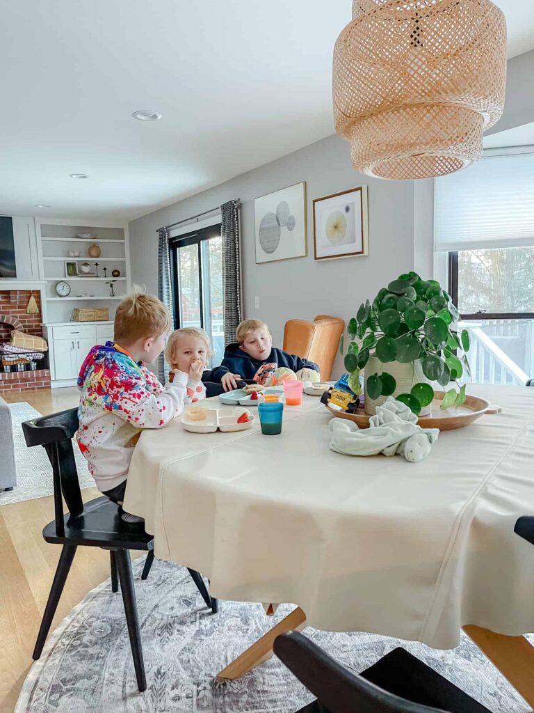 three boys sitting around a family table