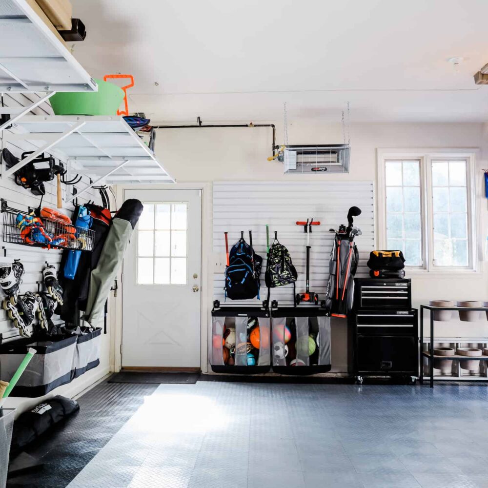 storage bins, a shoe rack, and cabinets inside a garage