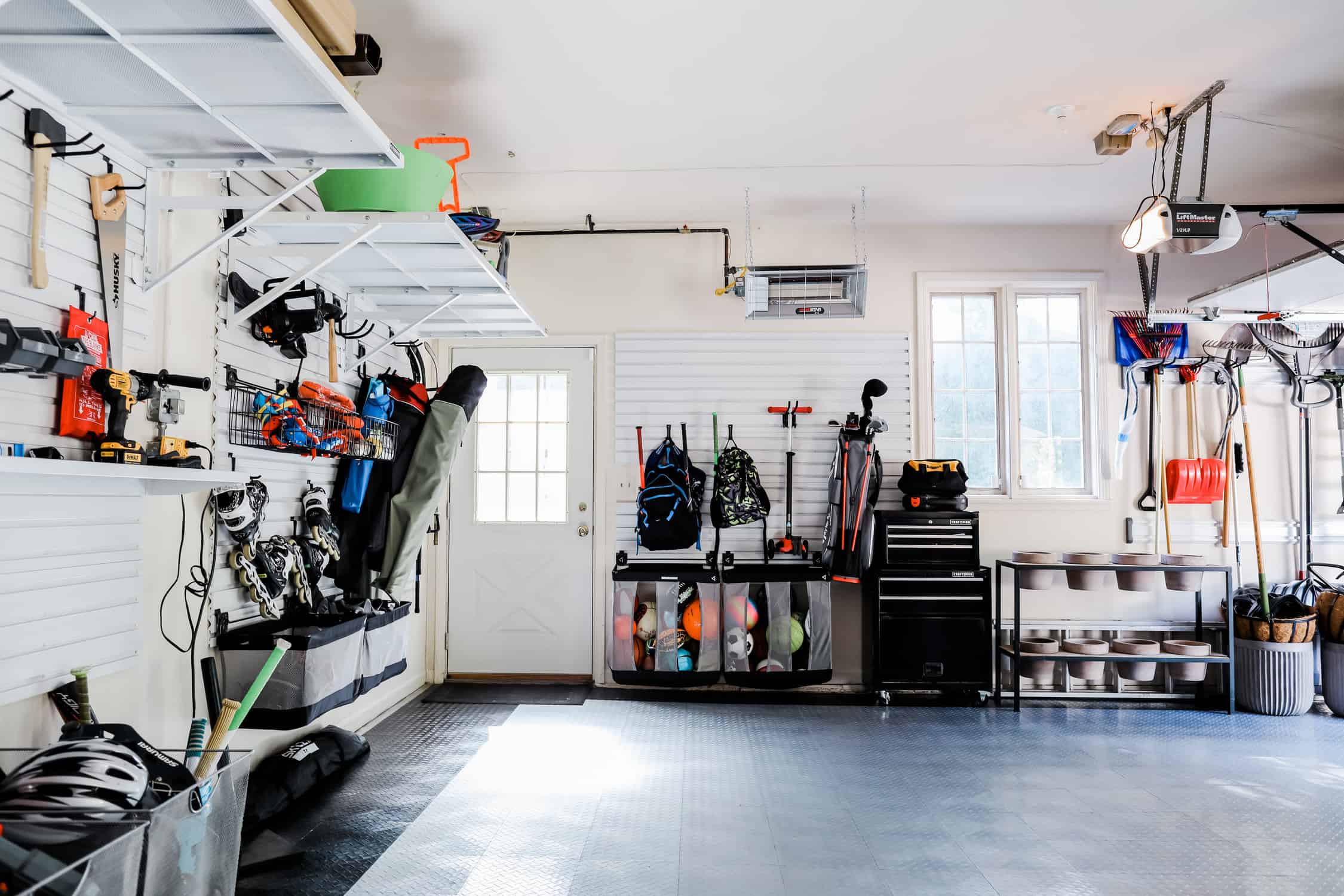 storage bins, a shoe rack, and cabinets inside a garage