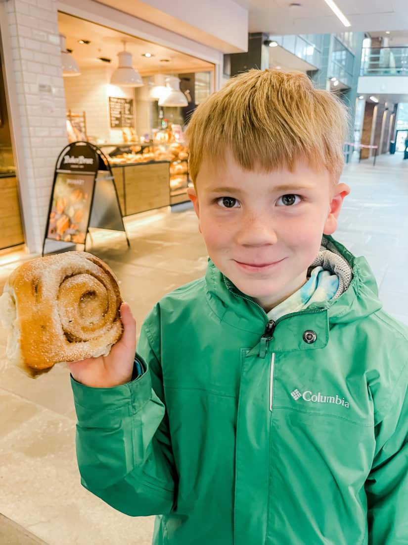 a boy holding a giant cinnamon roll