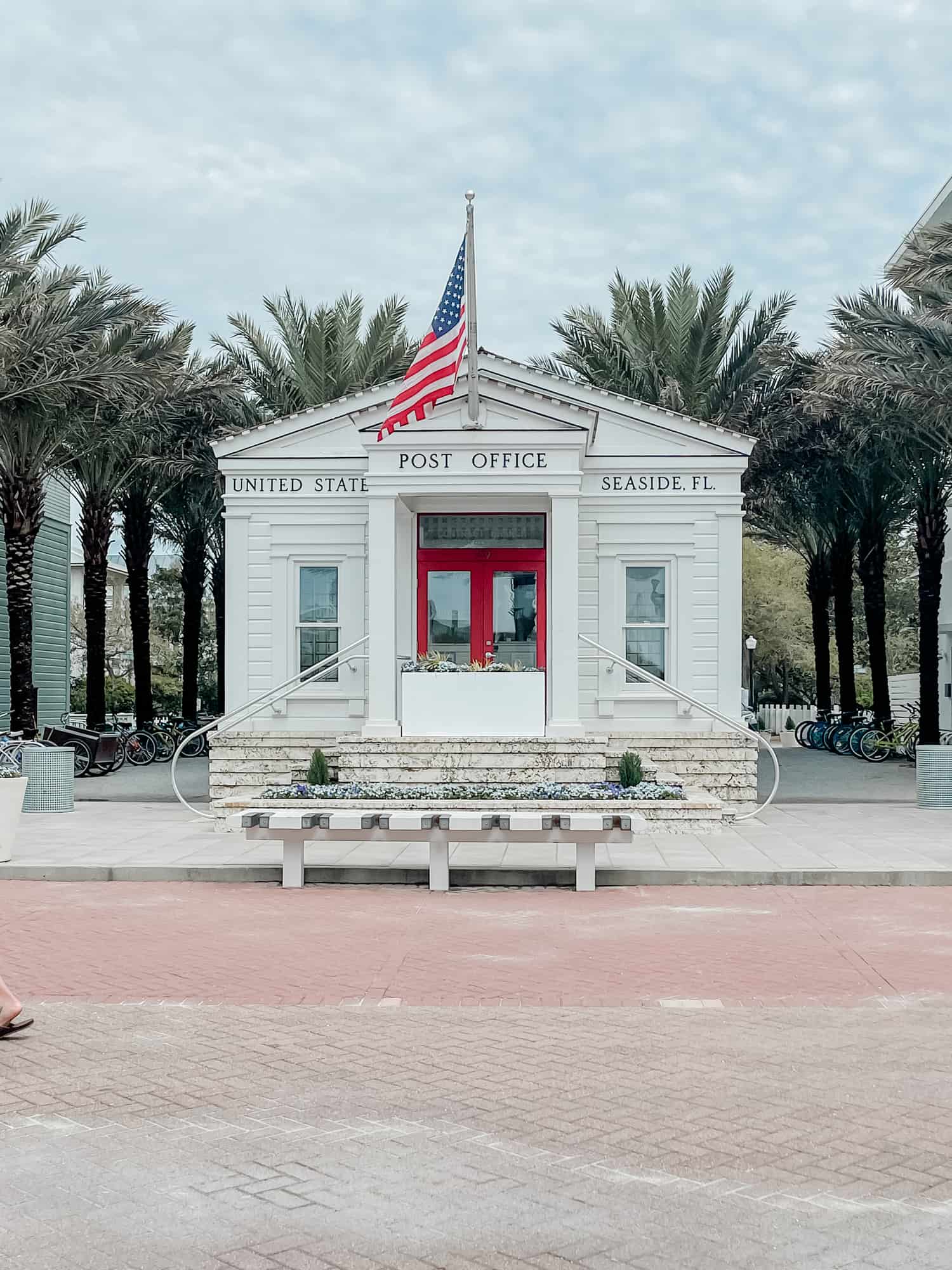 an old-fashioned white post office with an American flag 